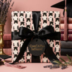 Pink graduation wrapping paper featuring cute tuxedo cats in graduation caps, by Wrapped Studios.