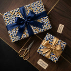 Luxury gift boxes with blue and gold geometric wrapping paper and silk bows, styled by Wrapped Studios.
