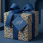Luxury gift box wrapped in abstract blue and gold paper with a navy ribbon and "A Gift" tag by Wrapped Studios.