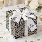 Luxury gift box with abstract blue and gold patterned wrapping paper, tied with a white ribbon by Wrapped Studios.