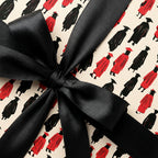 Graduation wrapping paper with a red and black graduate pattern and black satin bow by Wrapped Studios.