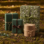 Elegant gifts wrapped in green geometric, solid green, and kraft paper with twine and ribbon on moss.