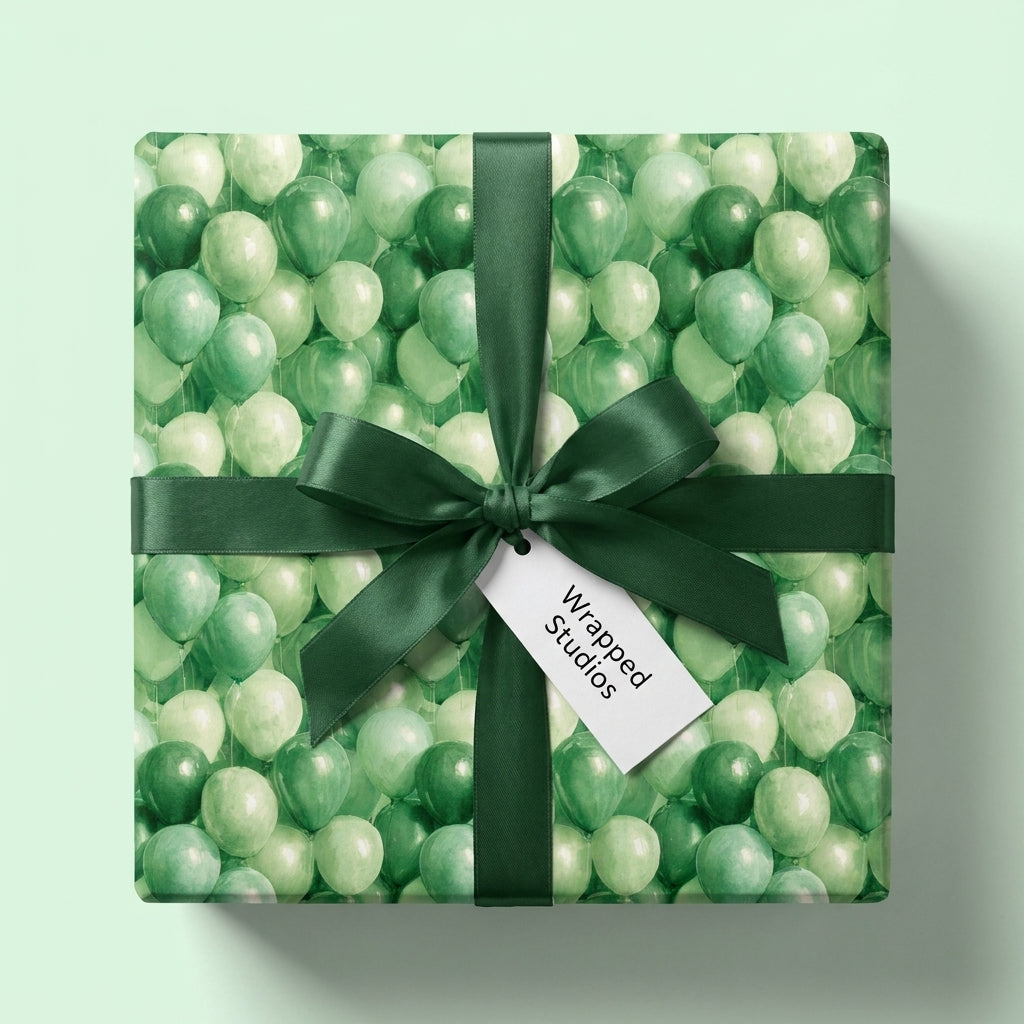 Green balloon birthday wrapping paper and gift wrap with a dark green satin bow by Wrapped Studios.