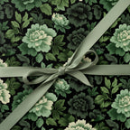 Elegant floral wrapping paper featuring a dark botanical print, tied with a sage green satin ribbon bow.
