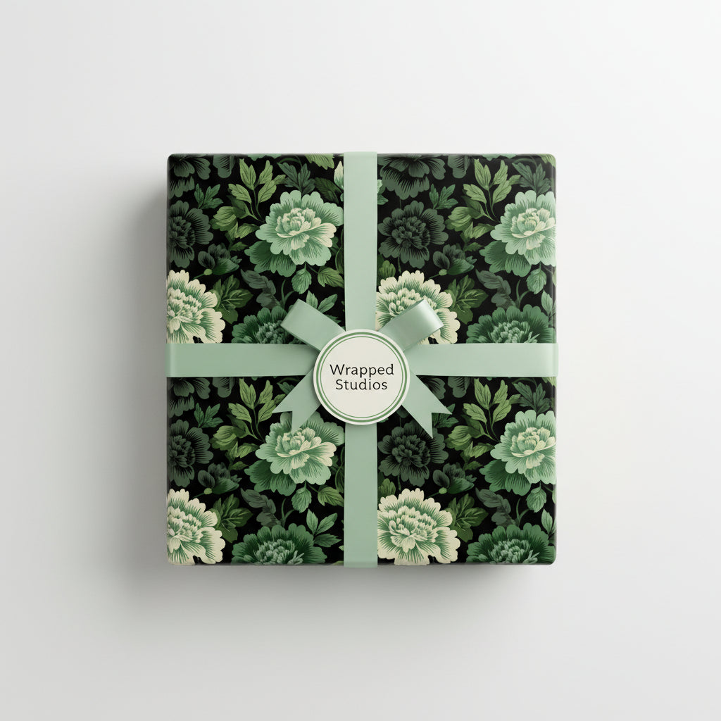 Square gift box in dark floral wrapping paper with sage green ribbon.
