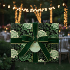 Elegant floral wrapping paper with green velvet ribbon and a "For You" gift tag, set outdoors with string lights.