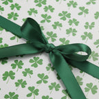 St. Patrick's Day gift wrapped in clover print wrapping paper with a green satin ribbon.