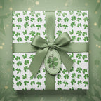 Square gift wrapped in clover St. Patrick's Day wrapping paper with sage green ribbon.