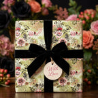 Vintage floral wrapping paper in sage green with a black velvet bow and 'With Love' tag by Wrapped Studios.