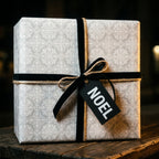 Luxury grey damask Christmas wrapping paper with a black velvet ribbon and Noel tag, by Wrapped Studios.