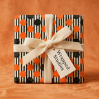 Retro Halloween wrapping paper with orange and black polka dots and velvet ribbon by Wrapped Studios.