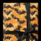 Square gift wrapped in bat-themed Halloween gift wrap, tied with a black satin bow.