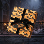 Square gift wrapped in orange bat Halloween wrapping paper with black velvet ribbon and "Spooky Greetings" tag.