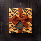 Spooky Halloween gift with bat print wrapping paper, rust ribbon, and "Creepy Treats" tag.
