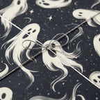 Whimsical ghost wrapping paper with silver cord bow for Halloween or spooky season gift wrapping.