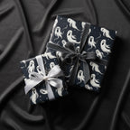 Two gifts wrapped in spooky ghost Halloween wrapping paper with ribbon bows.