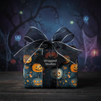 Square gift wrapped in Halloween-themed pumpkin wrapping paper with black ribbon bow.
