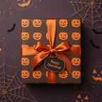 Square Halloween gift wrapped in pumpkin wrapping paper with an orange satin bow.
