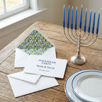 Hanukkah party invitation with blue Star of David envelope liner and menorah by Wrapped Studios.