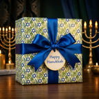 Luxury Hanukkah gift wrap with Star of David pattern, blue satin ribbon, and tag by Wrapped Studios.