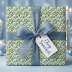 Hanukkah wrapping paper with Star of David and green leaves, blue ribbon, and Chag Sameach tag by Wrapped Studios.