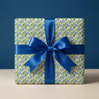 Hanukkah wrapping paper with Star of David and foliage, tied with a blue satin ribbon by Wrapped Studios.