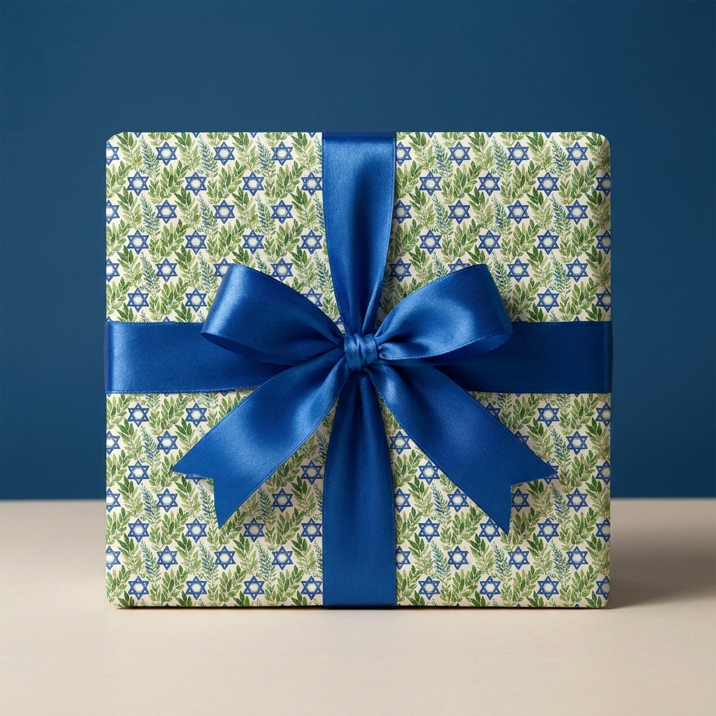 Hanukkah wrapping paper with Star of David and foliage, tied with a blue satin ribbon by Wrapped Studios.