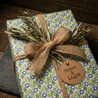 Elegant Hanukkah wrapping paper with Star of David & olive pattern, rustic burlap bow, by Wrapped Studios.