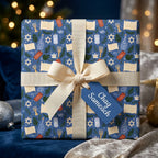 Blue Hanukkah wrapping paper with Star of David pattern, cream ribbon, and tag by Wrapped Studios.