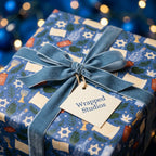 Hanukkah gift wrap with menorahs and Star of David, featuring a blue velvet bow by Wrapped Studios.