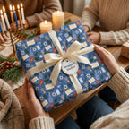 Blue Hanukkah wrapping paper with festive menorah design and cream ribbon by Wrapped Studios.