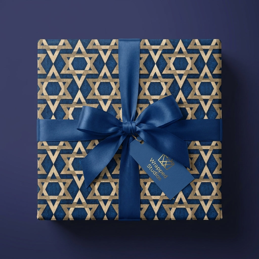 Elegant Hanukkah gift wrap with gold Star of David pattern and blue bow by Wrapped Studios.