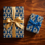 Hanukkah wrapping paper with gold Star of David pattern and elegant ribbons by Wrapped Studios.
