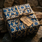 Hanukkah wrapping paper with blue and gold Star of David design and rustic twine, by Wrapped Studios.