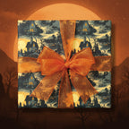 Square gift wrapped in spooky vintage Halloween wrapping paper with haunted house pattern and orange glitter bow.