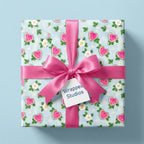 Heart watermelon wrapping paper with a pink satin bow on a gift box, by Wrapped Studios.