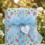 Light blue heart wrapping paper with a sheer bow and "With Love" tag for Valentine's Day by Wrapped Studios.