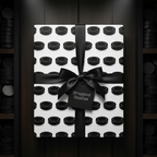Wrapped Studios hockey puck pattern wrapping paper with a sleek black satin ribbon bow.
