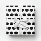 Hockey puck pattern gift wrapped with white bow and "SCORE!" tag.