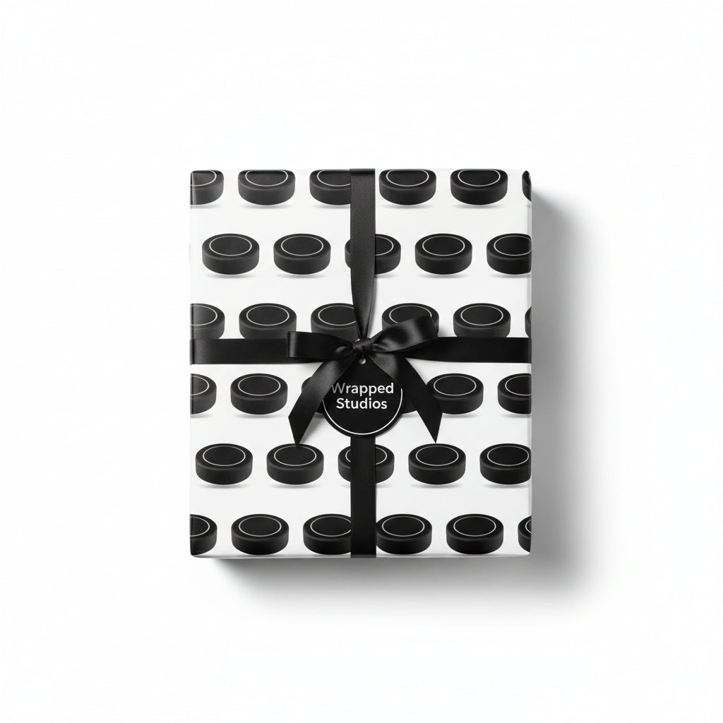 Wrapped gift in black hockey puck print wrapping paper and tied with a black satin ribbon.