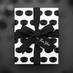 Hockey puck gift wrap with black ribbon and a "For You" tag.