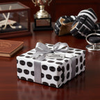 "Happy Anniversary" gift wrapped in hockey puck pattern paper with silver ribbon.