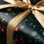 Luxury holiday wrapping paper with a dark green and gold bokeh pattern and gold ribbon by Wrapped Studios.