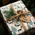 Rustic dog Christmas wrapping paper on a gift tied with twine and a For Dad tag by Wrapped Studios.