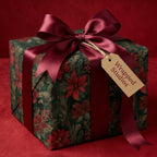 Elegant floral wrapping paper from Wrapped Studios with a dark red ribbon for Christmas gifts.