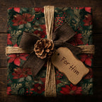 Elegant floral wrapping paper in red and green with a rustic pinecone and "For Him" tag.