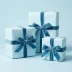 Elegant light blue gift boxes wrapped in solid color wrapping paper with velvet ribbon bows for birthday or holiday presents.