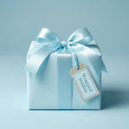Light blue wrapping paper on gift box with satin ribbon bow and tag, perfect for baby shower or elegant present.