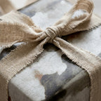 Rustic vintage wrapping paper with a textured crackle print and frayed linen ribbon by Wrapped Studios.