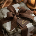 Rustic Christmas wrapping paper with brown burlap ribbon and Warm Wishes tag by Wrapped Studios.